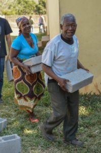 mensen in het dorp helpen mee aan de bouw van een nieuw leslokaal