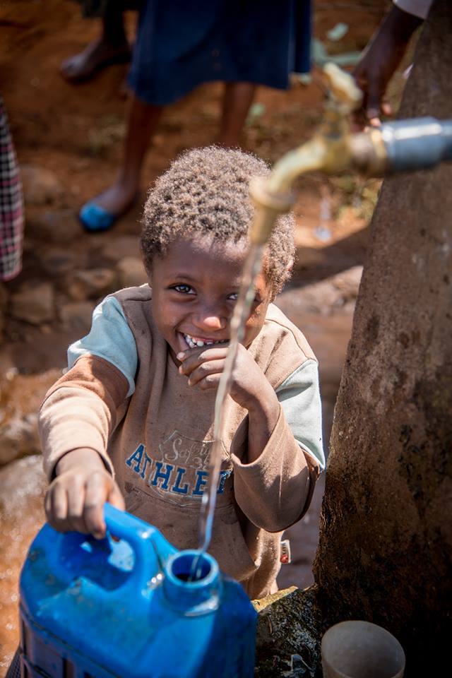 kinderen halen drinkwater